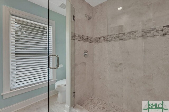 bathroom with toilet, a shower with door, and tile patterned floors