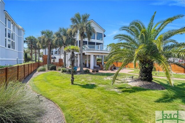 exterior space featuring a front lawn and a balcony