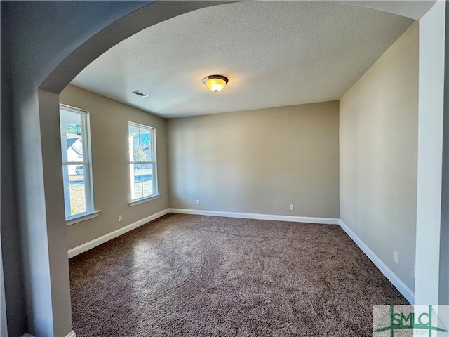 carpeted spare room with a textured ceiling