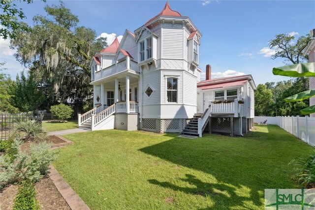 rear view of property with a yard