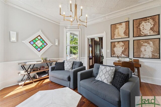 living room featuring hardwood / wood-style floors, a chandelier, and ornamental molding