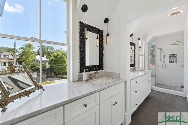 bathroom with walk in shower, tile patterned flooring, and vanity