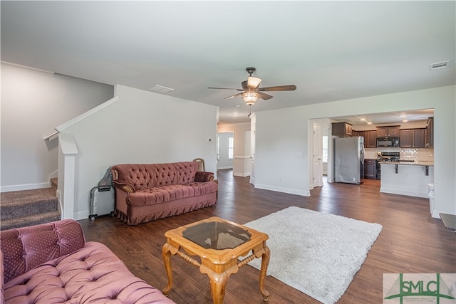 living room with ceiling fan and dark wood-type flooring