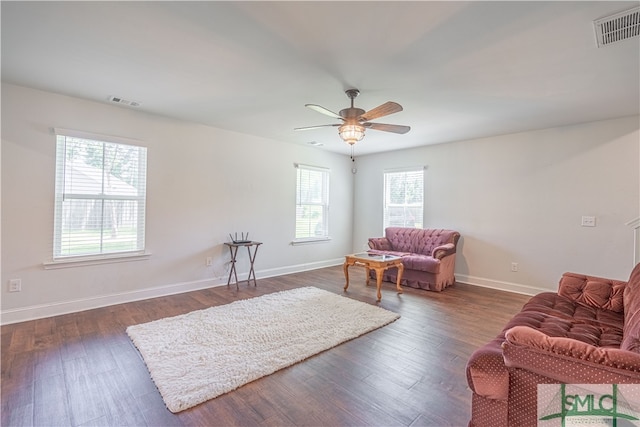 sitting room with ceiling fan and dark wood-type flooring