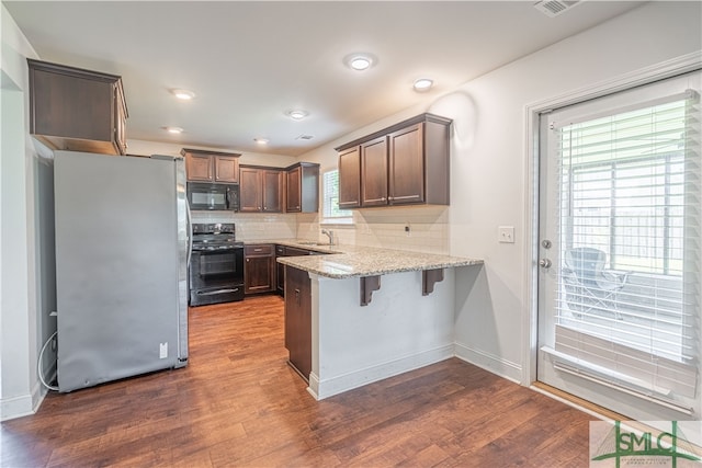 kitchen featuring plenty of natural light, black appliances, and hardwood / wood-style floors