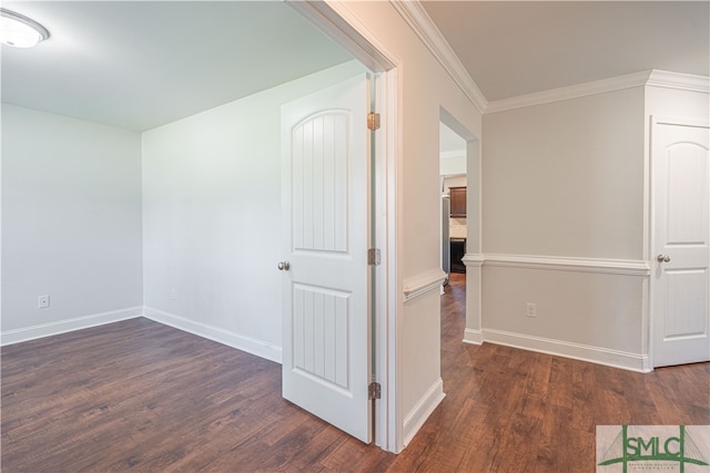 spare room featuring dark hardwood / wood-style floors and crown molding