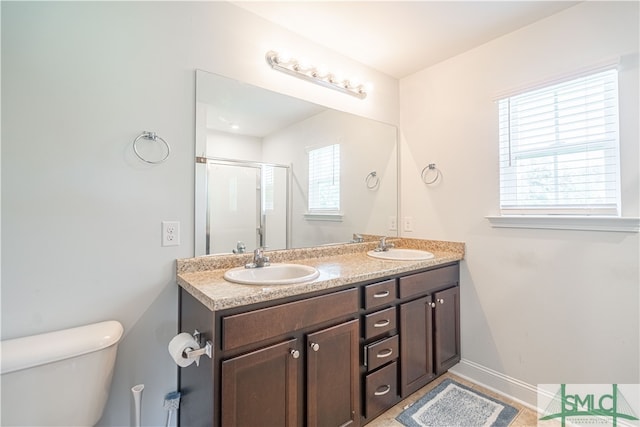 bathroom with toilet, dual bowl vanity, and tile patterned flooring