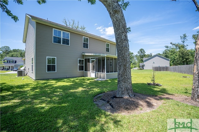 back of house with cooling unit, a sunroom, and a yard