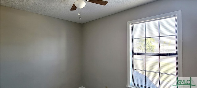 empty room with a textured ceiling and ceiling fan