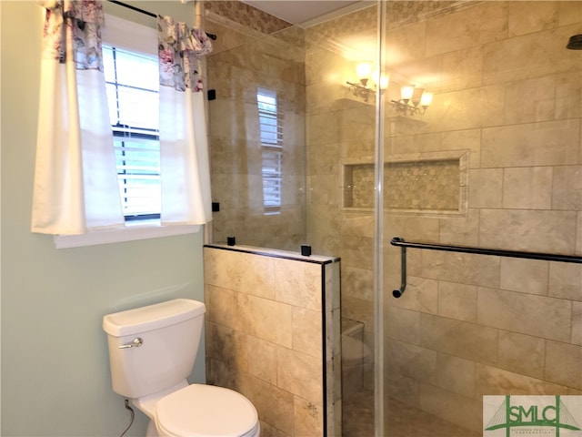 bathroom with a chandelier, toilet, a shower with shower door, and a healthy amount of sunlight