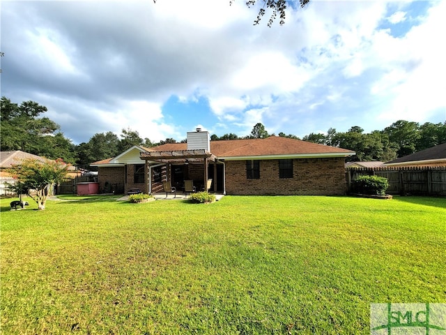 rear view of house featuring a lawn and a patio