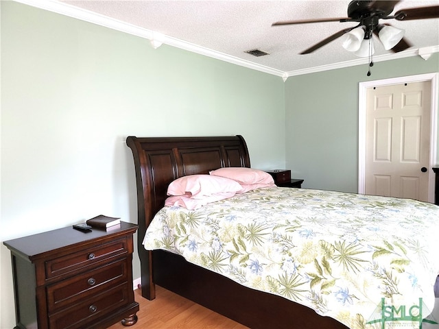 bedroom featuring a textured ceiling, light wood-type flooring, ceiling fan, and ornamental molding