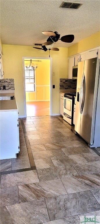 kitchen featuring ceiling fan, white cabinetry, a textured ceiling, and appliances with stainless steel finishes