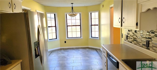 kitchen featuring backsplash, a healthy amount of sunlight, hanging light fixtures, and stainless steel appliances