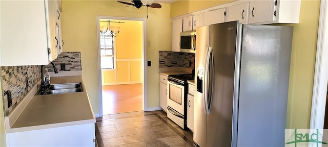 kitchen with decorative backsplash, appliances with stainless steel finishes, white cabinetry, and sink