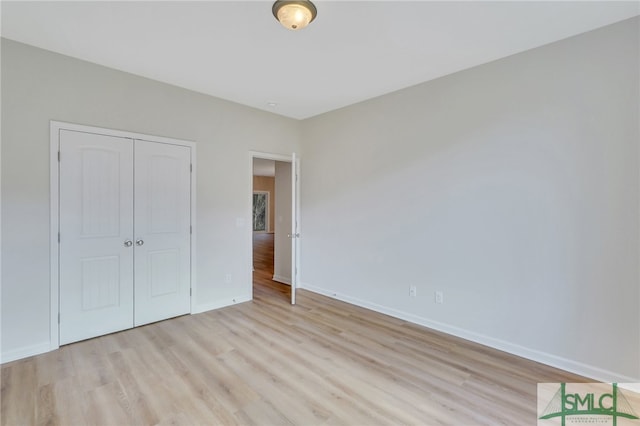 unfurnished bedroom featuring light wood-type flooring and a closet