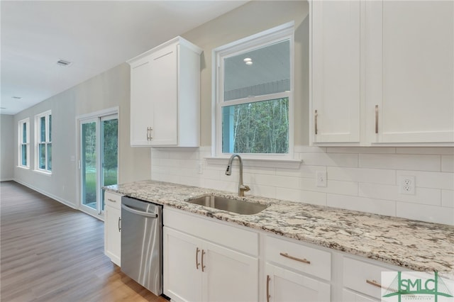 kitchen with white cabinets, dishwasher, and sink