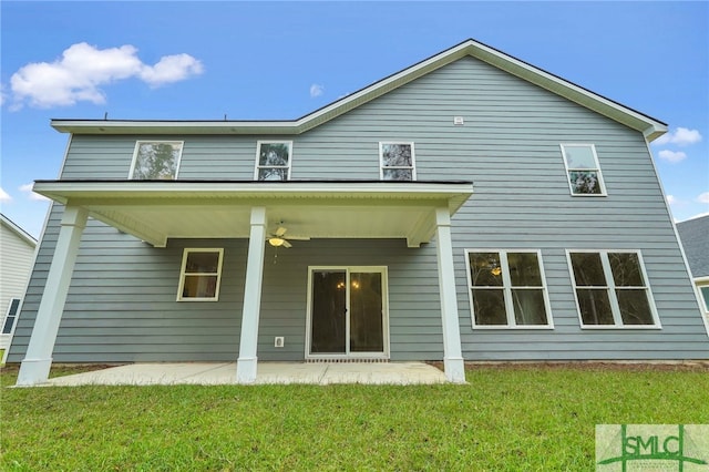 back of house with ceiling fan and a yard