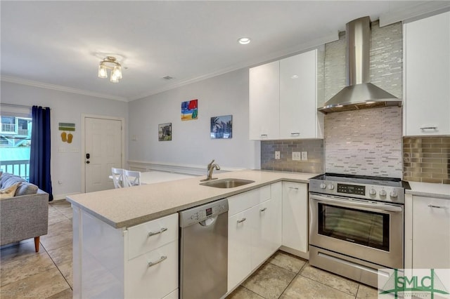 kitchen with appliances with stainless steel finishes, wall chimney range hood, sink, white cabinetry, and kitchen peninsula