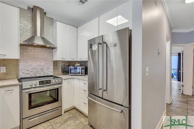 kitchen with white cabinetry, ornamental molding, stainless steel appliances, and wall chimney exhaust hood