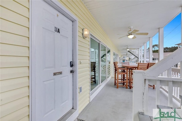 doorway to property with ceiling fan and a porch