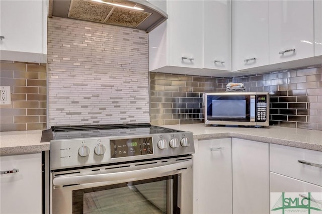 kitchen featuring appliances with stainless steel finishes, tasteful backsplash, custom exhaust hood, and white cabinets