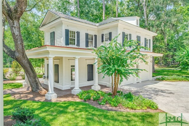 view of front of house featuring a garage, covered porch, and a front yard