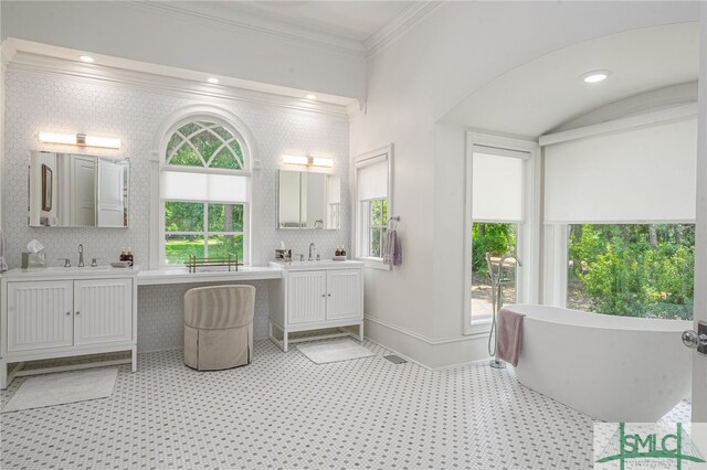 bathroom with crown molding, a washtub, and vanity