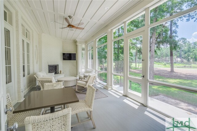 sunroom with ceiling fan and wooden ceiling