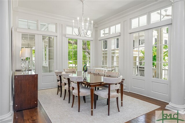 sunroom with decorative columns, a chandelier, and a healthy amount of sunlight