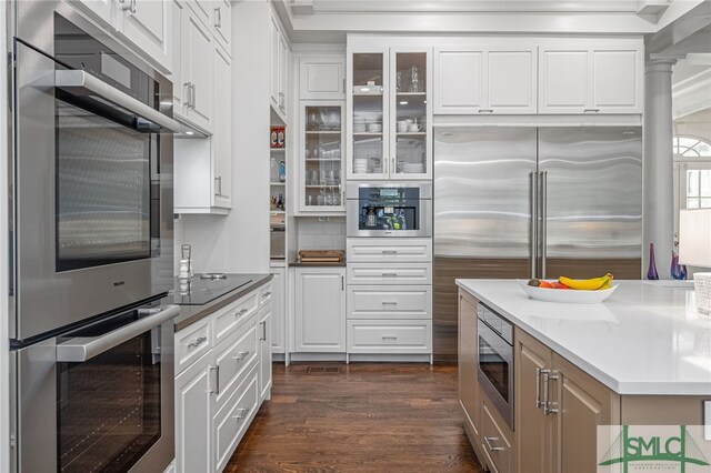 kitchen with white cabinets, appliances with stainless steel finishes, and dark hardwood / wood-style floors