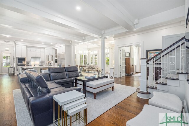 living room featuring ornate columns, beamed ceiling, and dark hardwood / wood-style floors