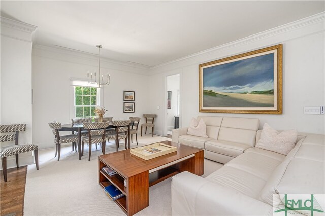 living room featuring wood-type flooring, ornamental molding, and an inviting chandelier