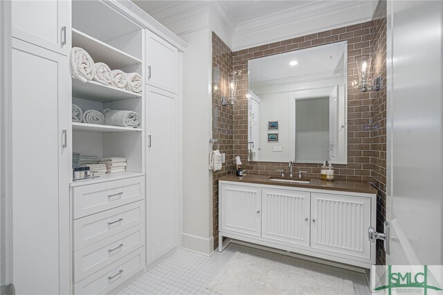 bathroom with tile patterned flooring, vanity, backsplash, and crown molding