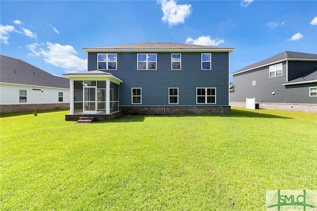 back of property with a sunroom and a yard