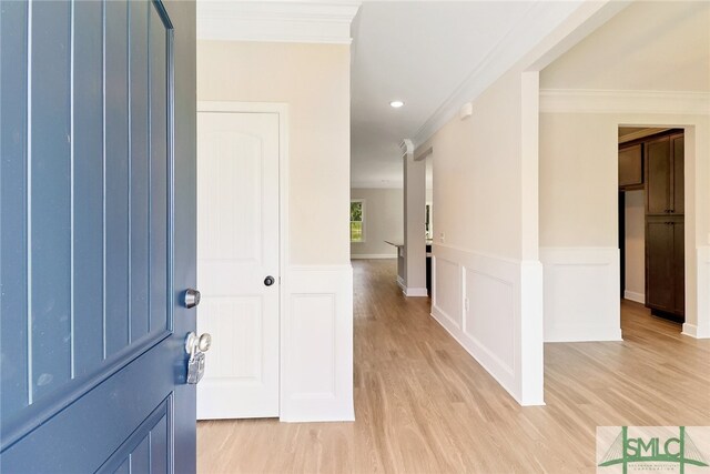 corridor featuring crown molding and light hardwood / wood-style floors