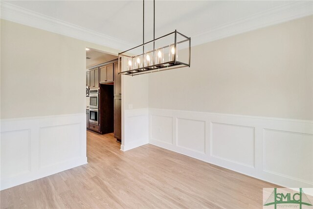 unfurnished dining area featuring crown molding and light hardwood / wood-style floors