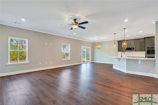 51 Hanover Pl, Richmond Hill, GA 31324 - unfurnished living room with baseboards, dark wood-style flooring, visible vents, a sink, and ceiling fan with notable chandelier