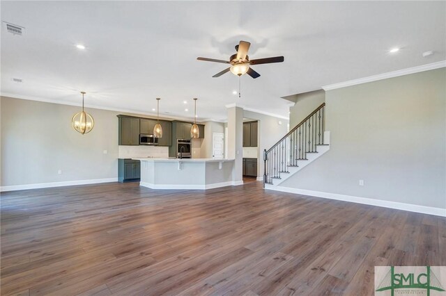 51 Hanover Pl, Richmond Hill, GA 31324 - unfurnished living room featuring visible vents, baseboards, ceiling fan with notable chandelier, and ornamental molding