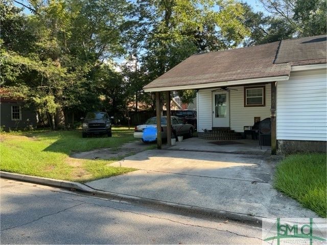 view of front of property featuring a carport and a front lawn