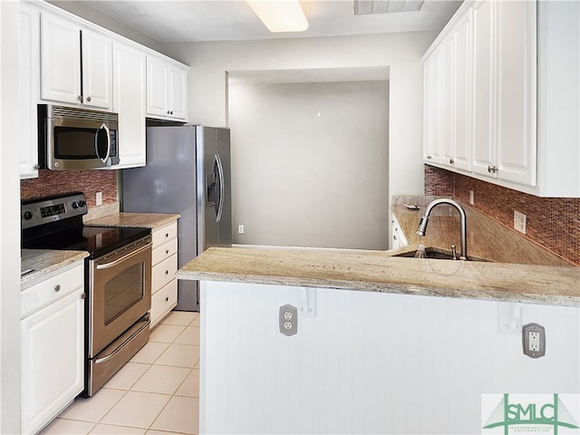 kitchen with backsplash, sink, appliances with stainless steel finishes, kitchen peninsula, and white cabinets