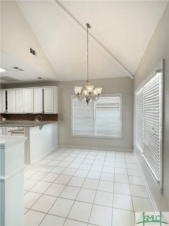 kitchen with decorative backsplash, an inviting chandelier, white cabinetry, pendant lighting, and light tile patterned floors