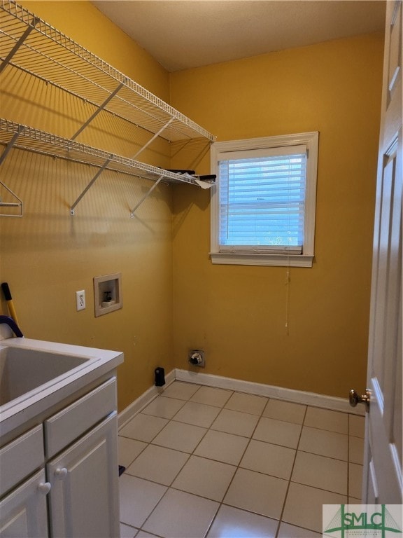 laundry area featuring sink, light tile patterned floors, cabinets, and hookup for a washing machine