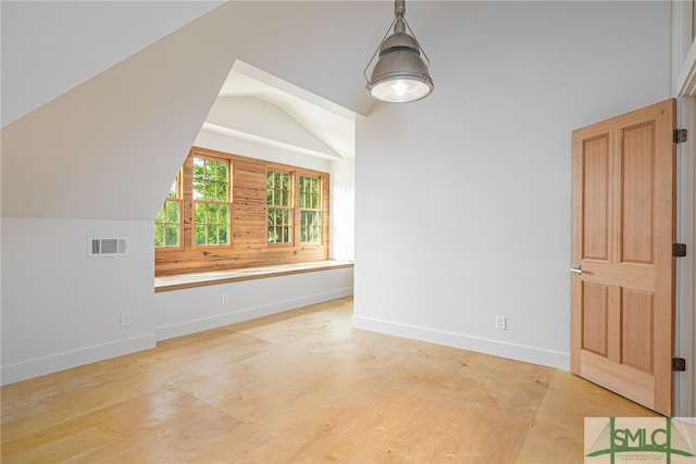 bonus room featuring baseboards, visible vents, and vaulted ceiling