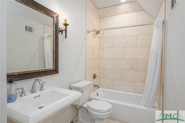 full bath featuring toilet, shower / bath combination with curtain, visible vents, and a sink