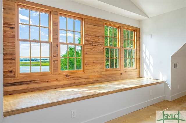 doorway featuring lofted ceiling, visible vents, a wealth of natural light, and baseboards