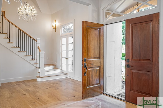 foyer entrance featuring stairs, a wealth of natural light, and light wood-style floors