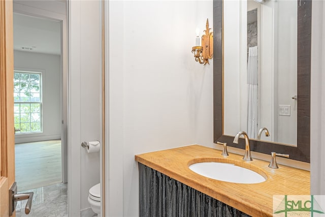 bathroom featuring visible vents, vanity, and toilet