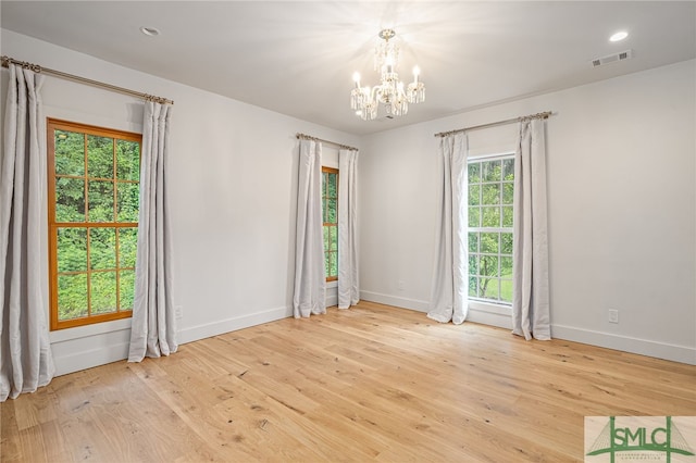 unfurnished room featuring a notable chandelier, recessed lighting, wood finished floors, visible vents, and baseboards