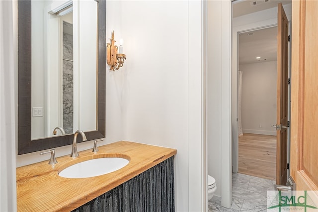 bathroom featuring marble finish floor, vanity, and toilet